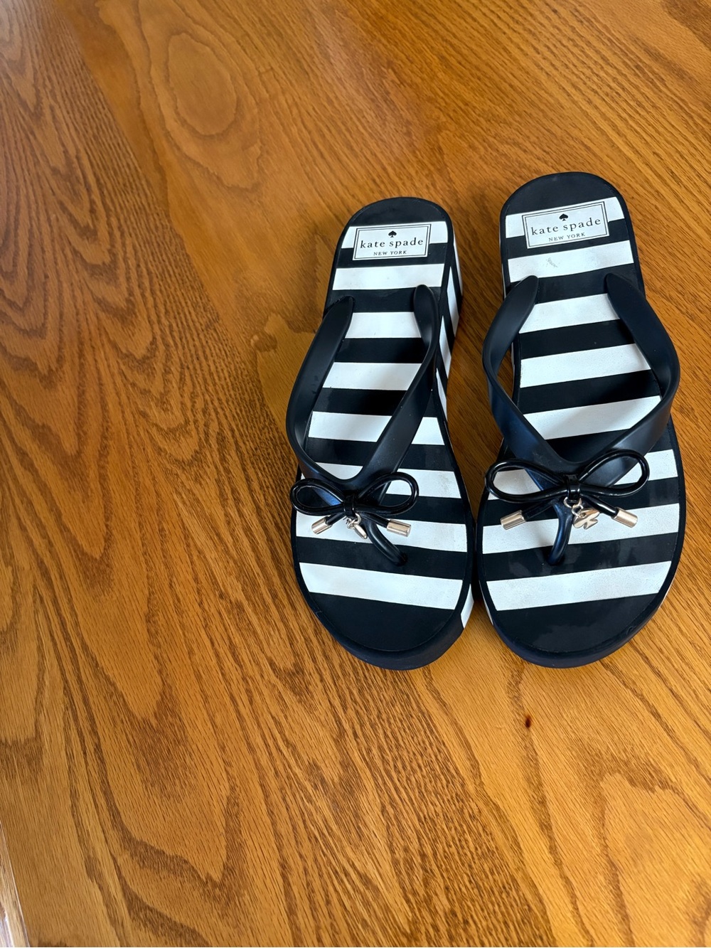 Kate Spade black and white striped flip sandals.